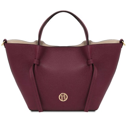 Maroon handbag with a gold logo on a white background